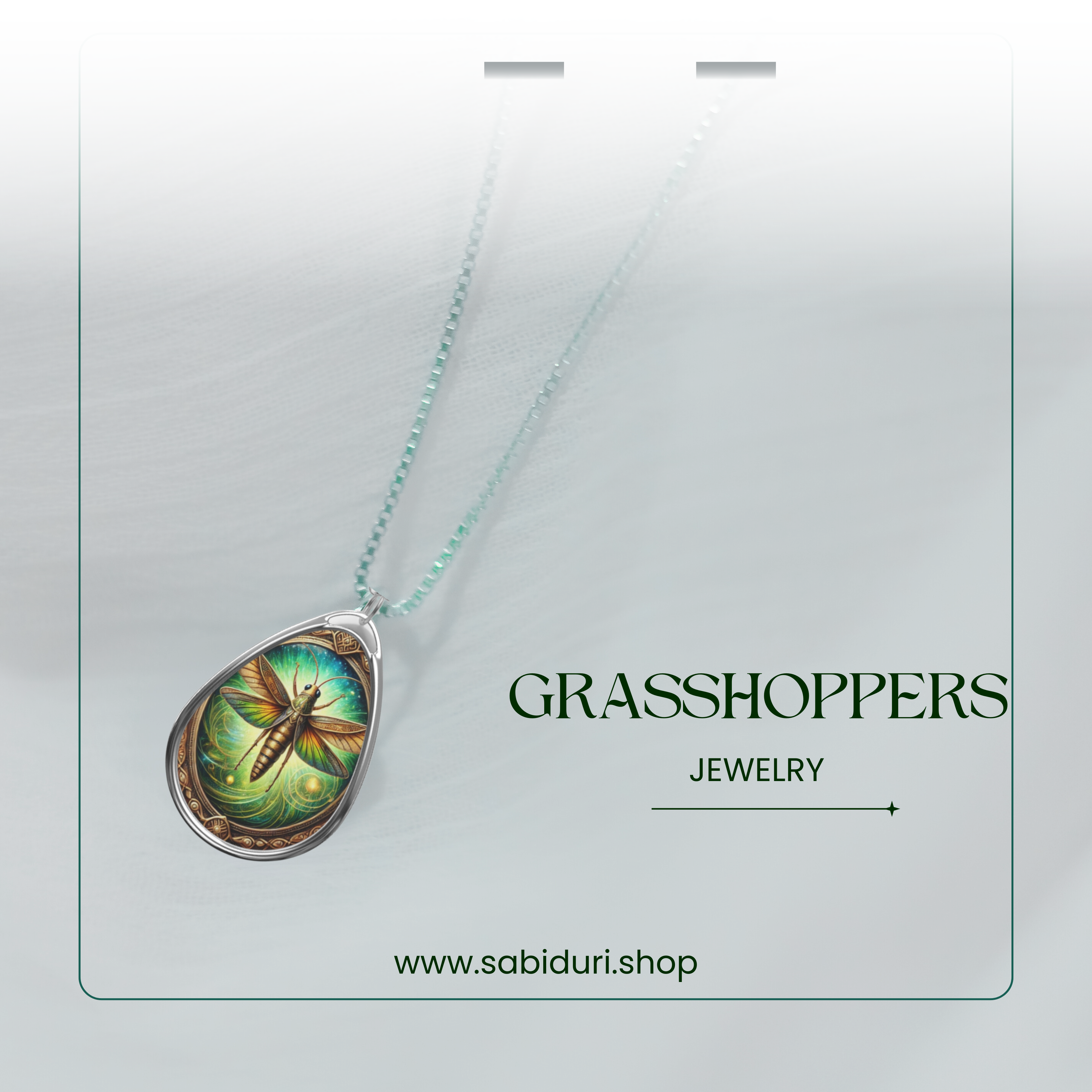 A close-up of the grasshopper spirit animal pendant, featuring a vibrant and magical insect design encased in a silver setting. The necklace rests on sheer white fabric with the words "GRASSHOPPERS JEWELRY" and "www.sabiduri.shop" in a refined, nature-inspired typography.