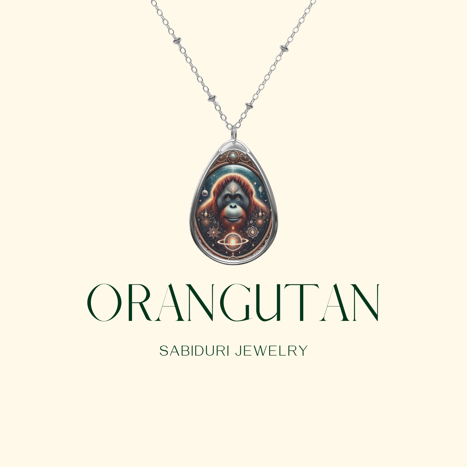 A close-up of the same teardrop-shaped pendant, showcasing an orangutan with a cosmic-inspired background, blending earthy tones and golden elements. Below, the text "ORANGUTAN" and "SABIDURI JEWELRY" are displayed in an elegant serif font.