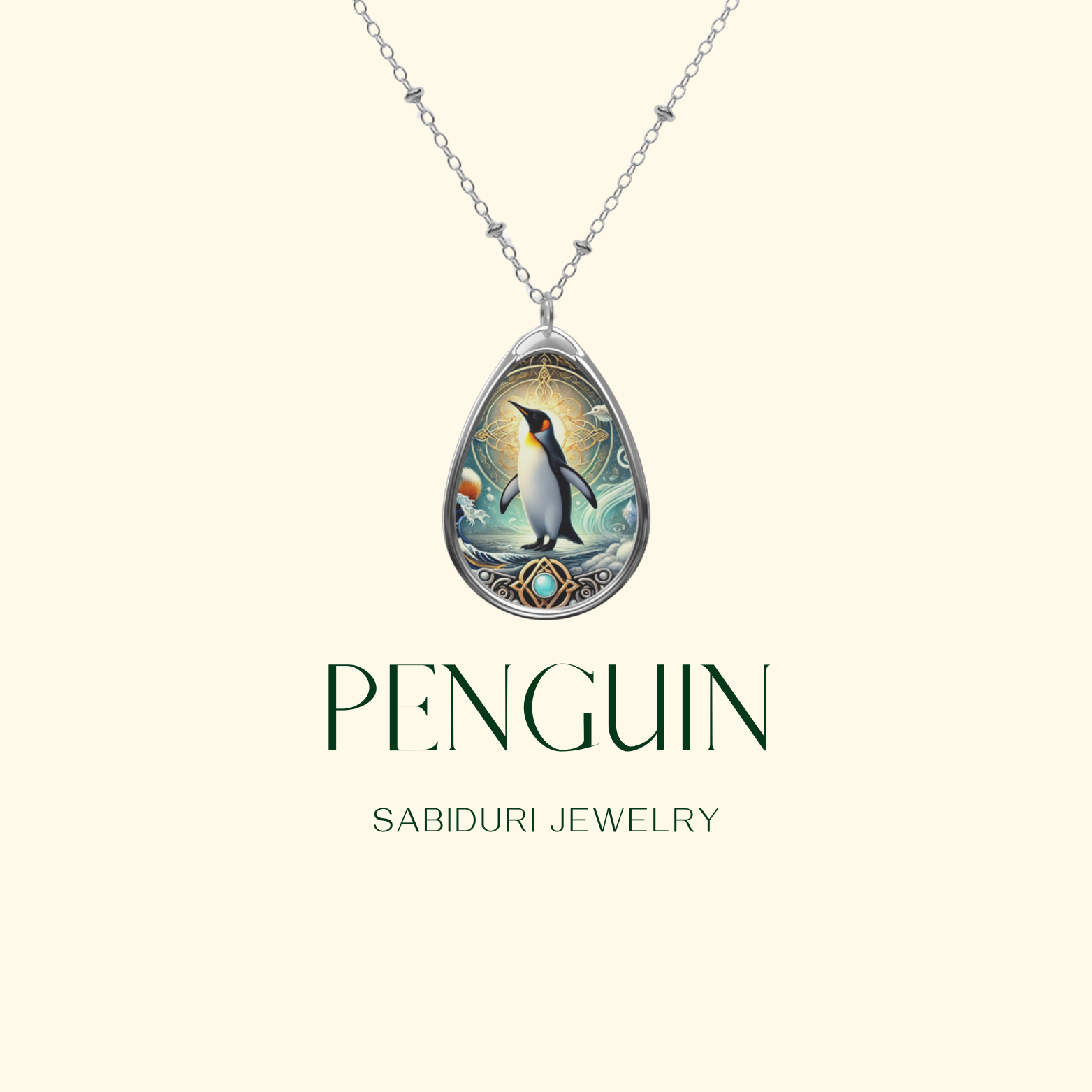 A close-up of the same penguin pendant, suspended from a delicate silver chain, against a light beige background. The words "PENGUIN" and "SABIDURI JEWELRY" are elegantly written below.