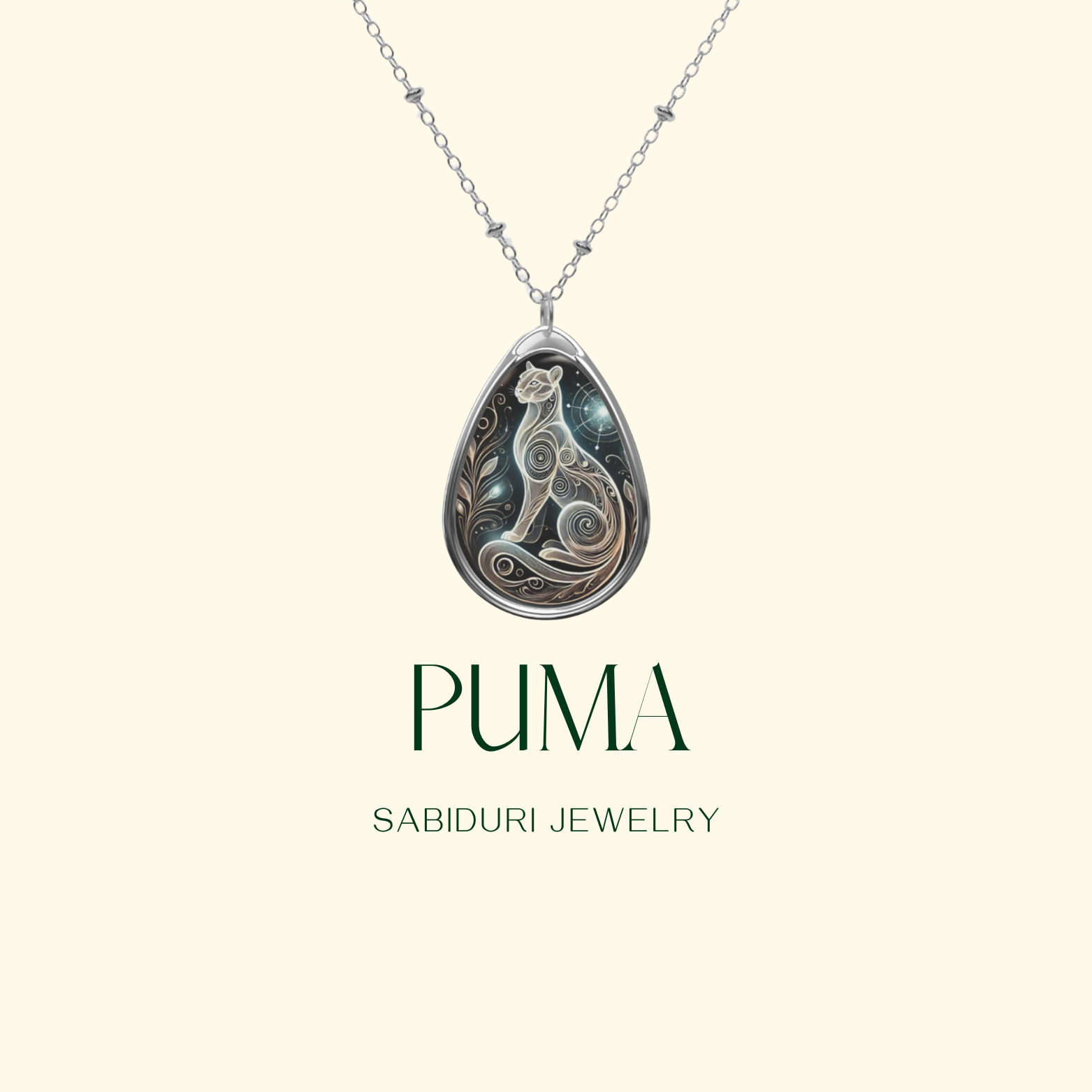 A teardrop-shaped pendant with an artistic depiction of a puma in an intricate, swirling style. The necklace hangs against a minimalist cream-colored background, with "PUMA" and "SABIDURI JEWELRY" written beneath.