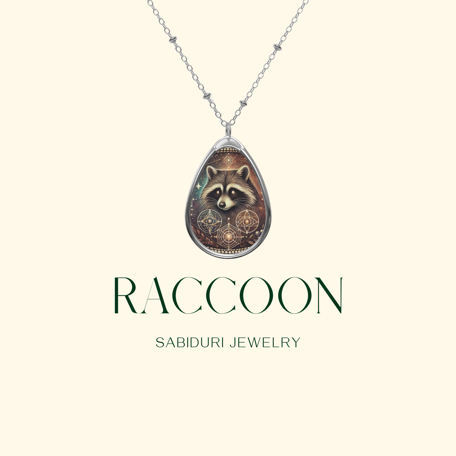 Elegant raccoon pendant necklace suspended from a delicate silver chain, displayed on a light beige background with the text 'RACCOON' and 'SABIDURI JEWELRY' in a modern font.