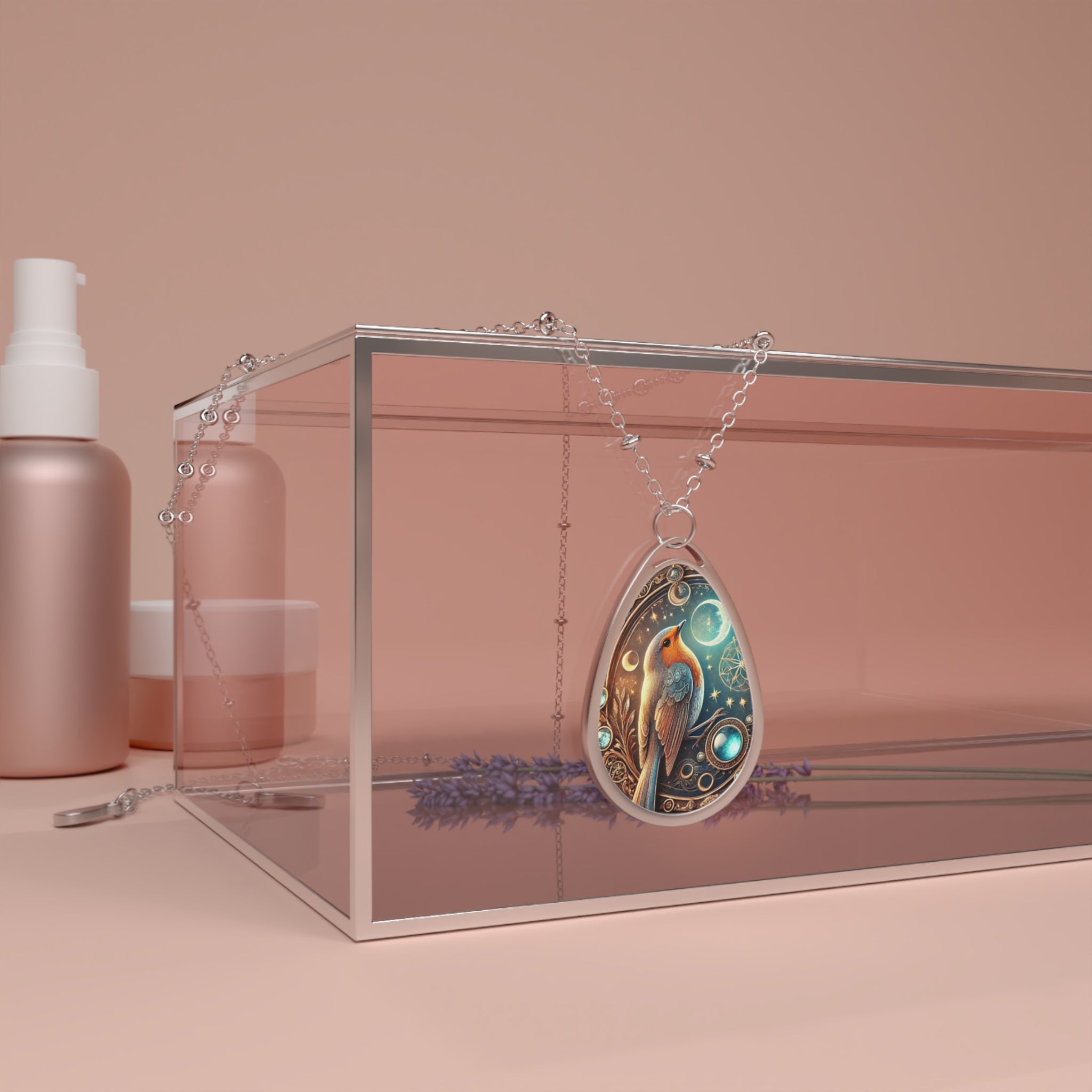 The robin necklace draped over a transparent jewelry box, surrounded by soft pink-toned skincare products and dried lavender. The pendant features a beautifully detailed robin design with celestial motifs and a luminous gemstone accent.