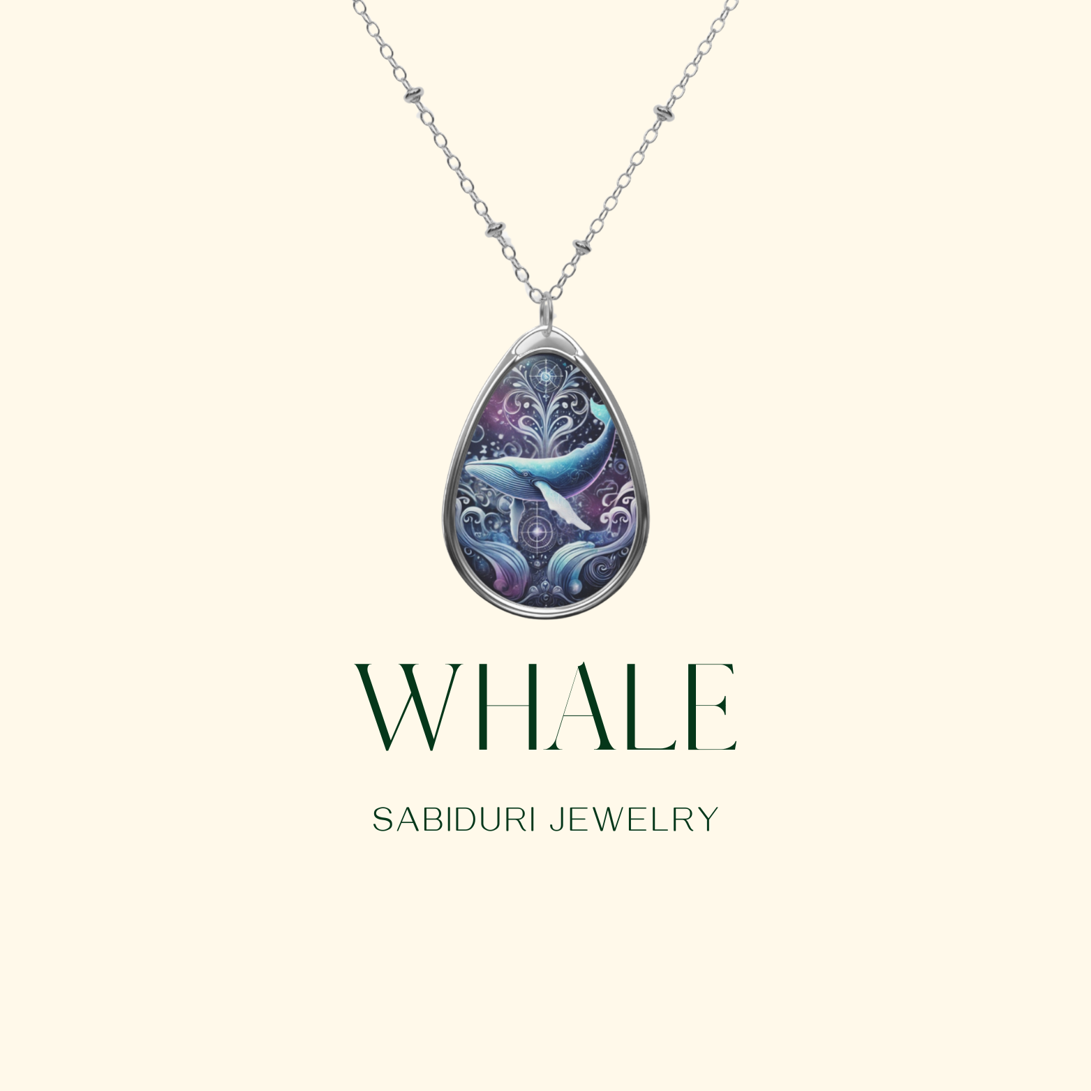 A close-up of a teardrop-shaped whale pendant necklace, suspended on a silver chain. The pendant features a majestic blue whale, surrounded by decorative ocean waves and celestial patterns in purple and blue hues. The text reads: 'WHALE' and 'SABIDURI JEWELRY'.