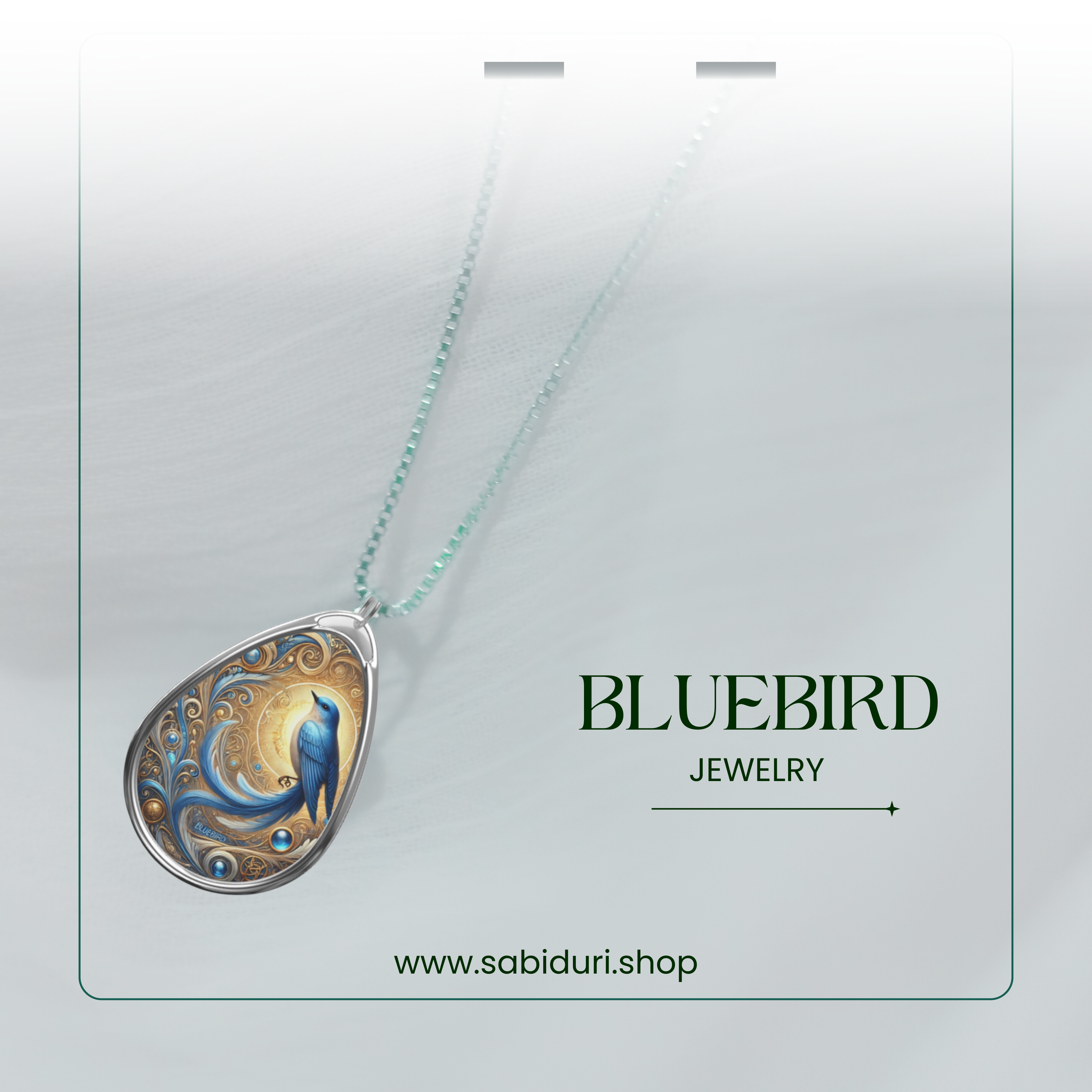 A close-up of the bluebird necklace against a soft, ethereal white backdrop, emphasizing its detailed golden swirls and deep blue gemstone-like accents. The text "BLUEBIRD JEWELRY" is placed to the right, with the website "www.sabiduri.shop" at the bottom.