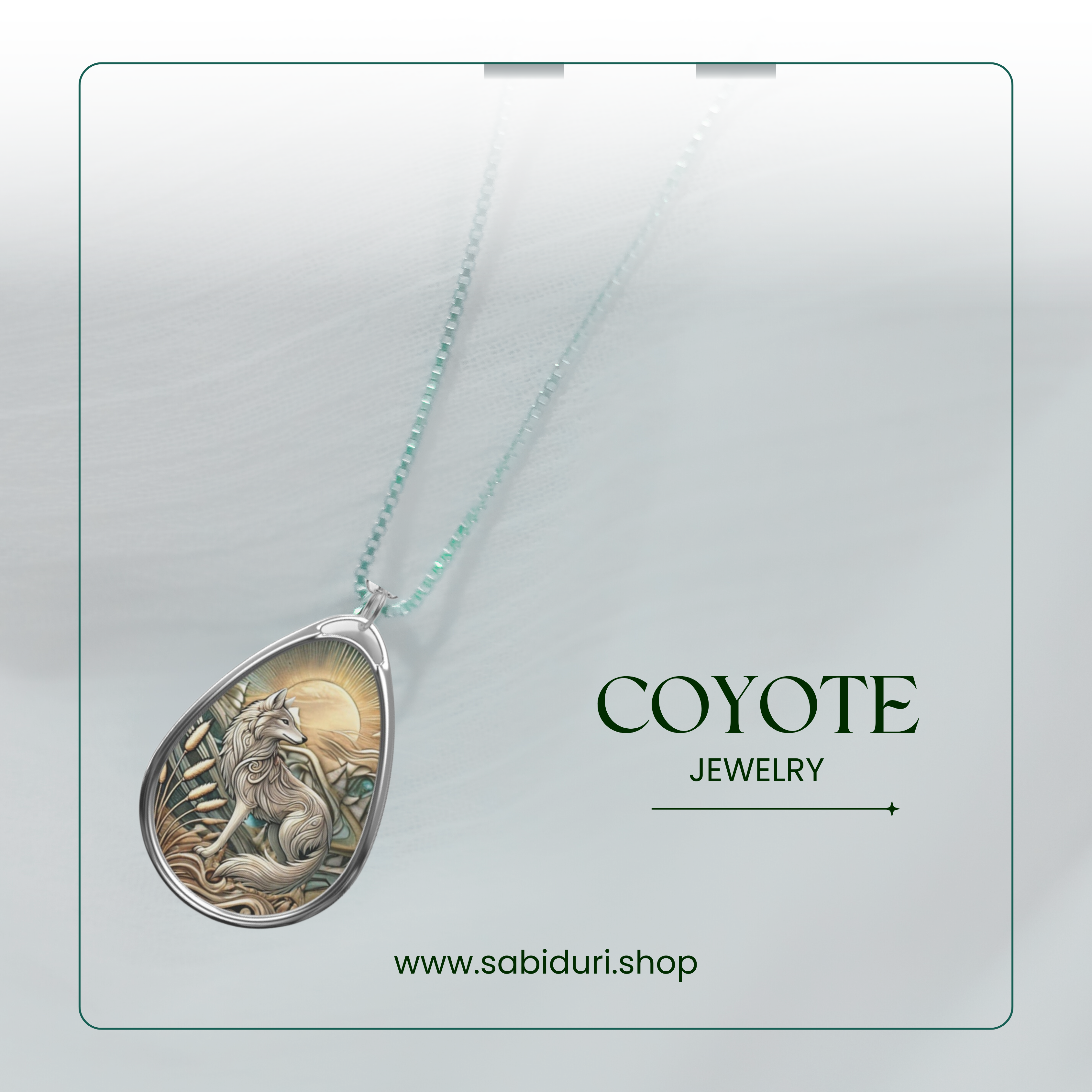 A close-up of a teardrop-shaped necklace pendant featuring an intricately detailed coyote design with the sun rising in the background. The pendant hangs from a delicate chain and is advertised under the name "COYOTE JEWELRY," with a website link www.sabiduri.shop at the bottom.