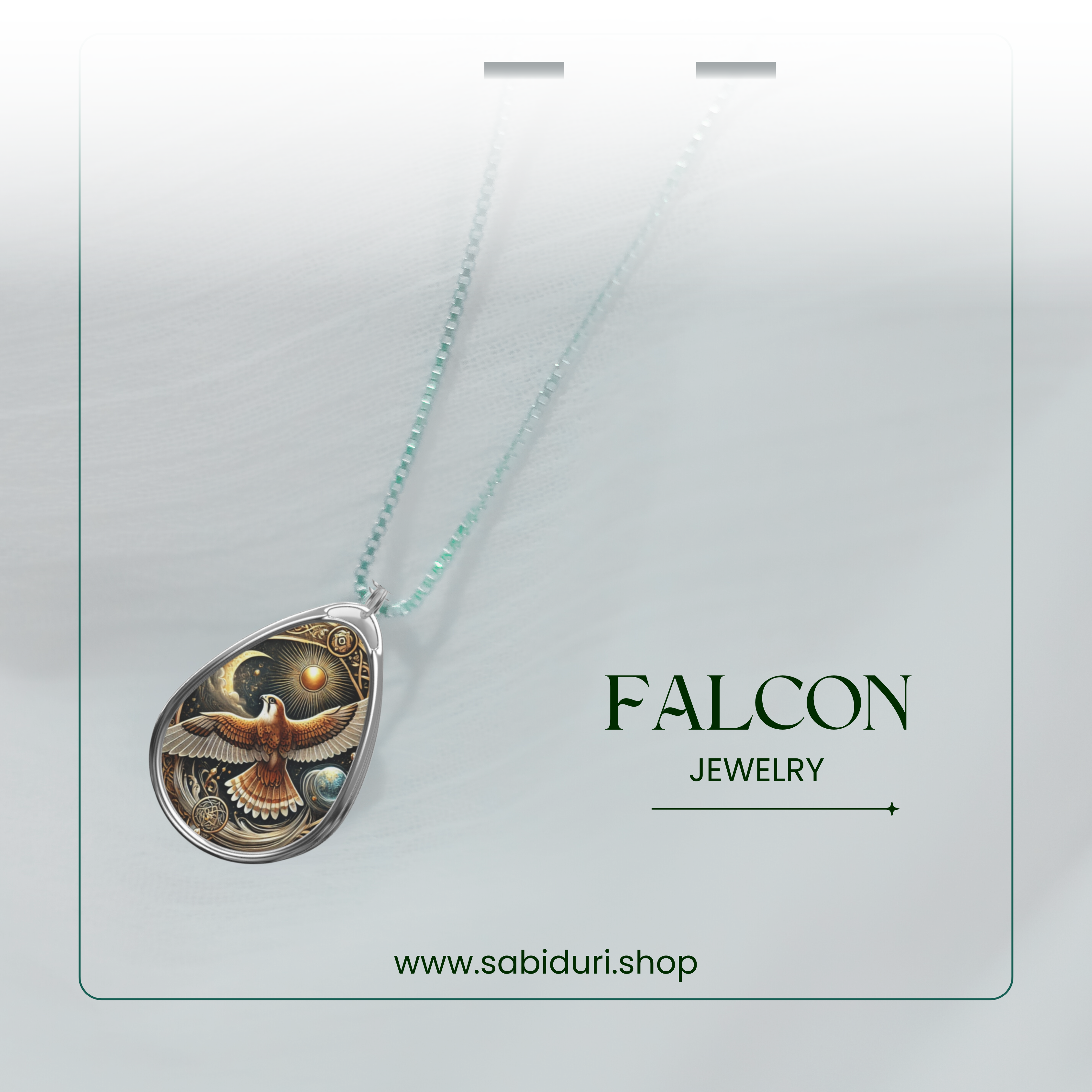 The Falcon pendant is suspended from a beaded silver chain, photographed against a soft, dreamy white background. The glowing golden and bronze tones in the pendant’s design highlight the falcon’s detailed wingspan, giving it a celestial and regal appearance. Below, the text reads "FALCON JEWELRY" and "www.sabiduri.shop."