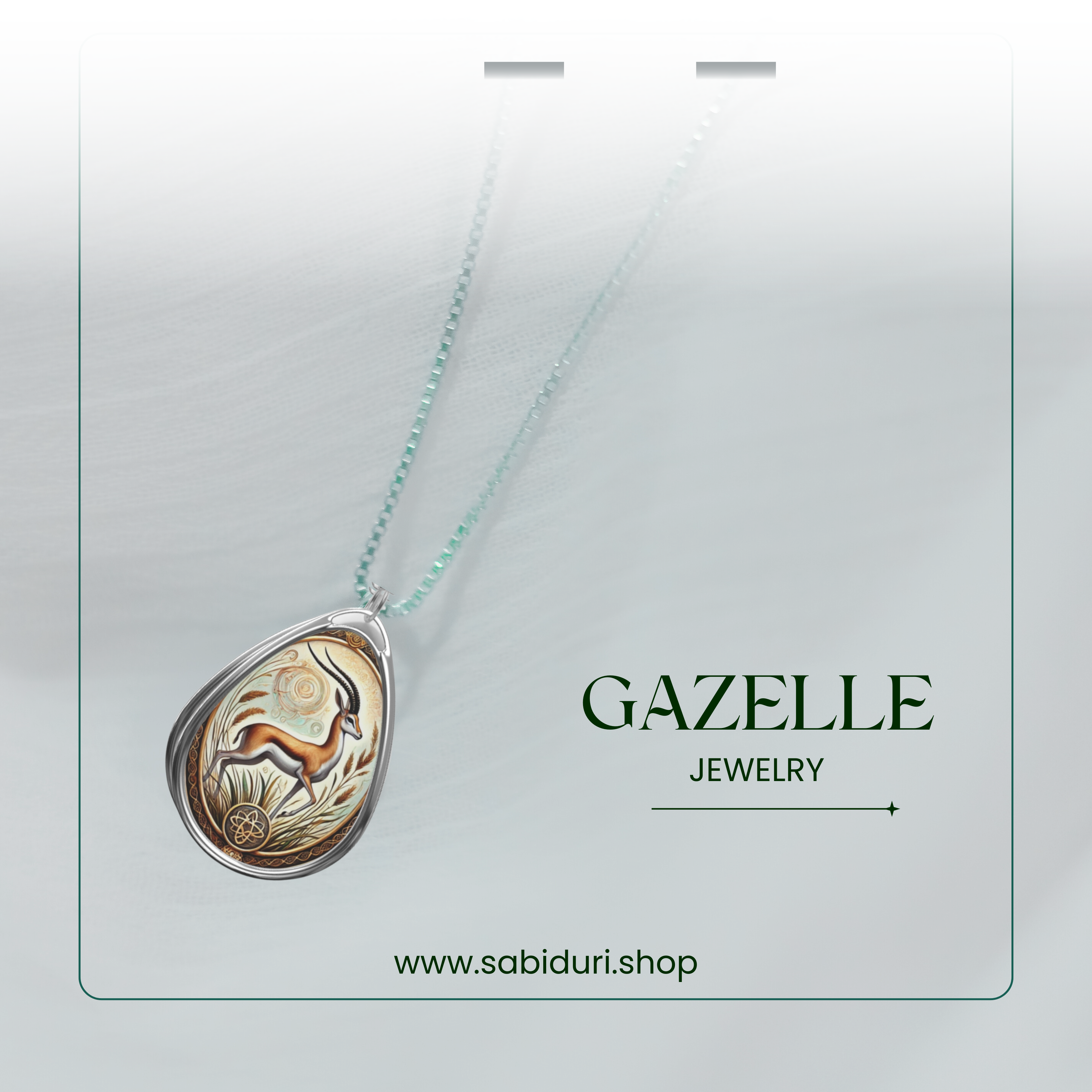 The Gazelle spirit animal pendant is displayed on a promotional card with a soft white gradient background. The silver-framed necklace showcases a leaping gazelle among stylized foliage, radiating an ethereal golden glow. The text "GAZELLE JEWELRY" is elegantly positioned to the right, with the website "www.sabiduri.shop" at the bottom.