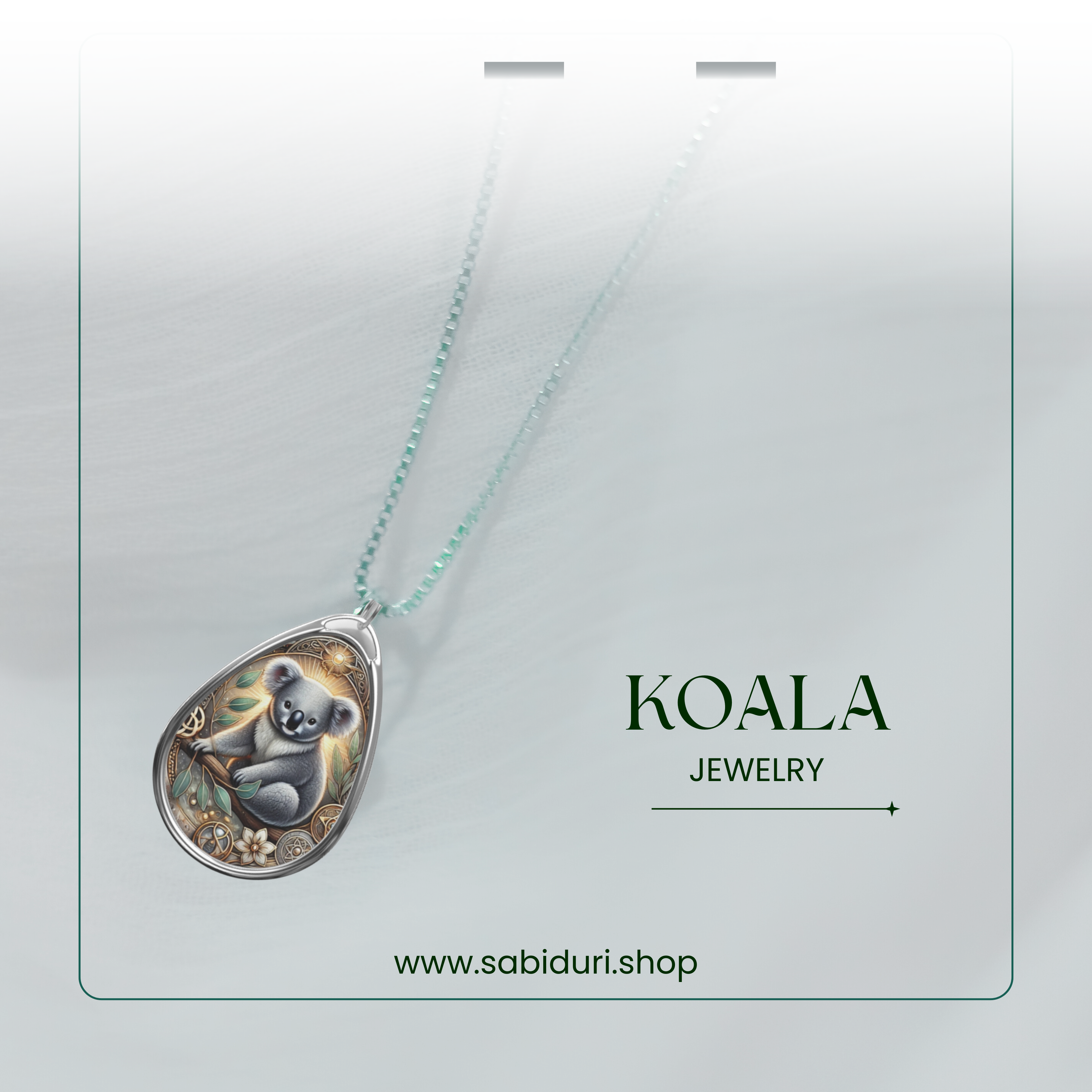 The Koala necklace displayed on a jewelry card-style layout, featuring a gradient soft white background. The pendant's intricate design highlights the koala with delicate floral and golden patterns. The text "KOALA JEWELRY" and "www.sabiduri.shop" is displayed.