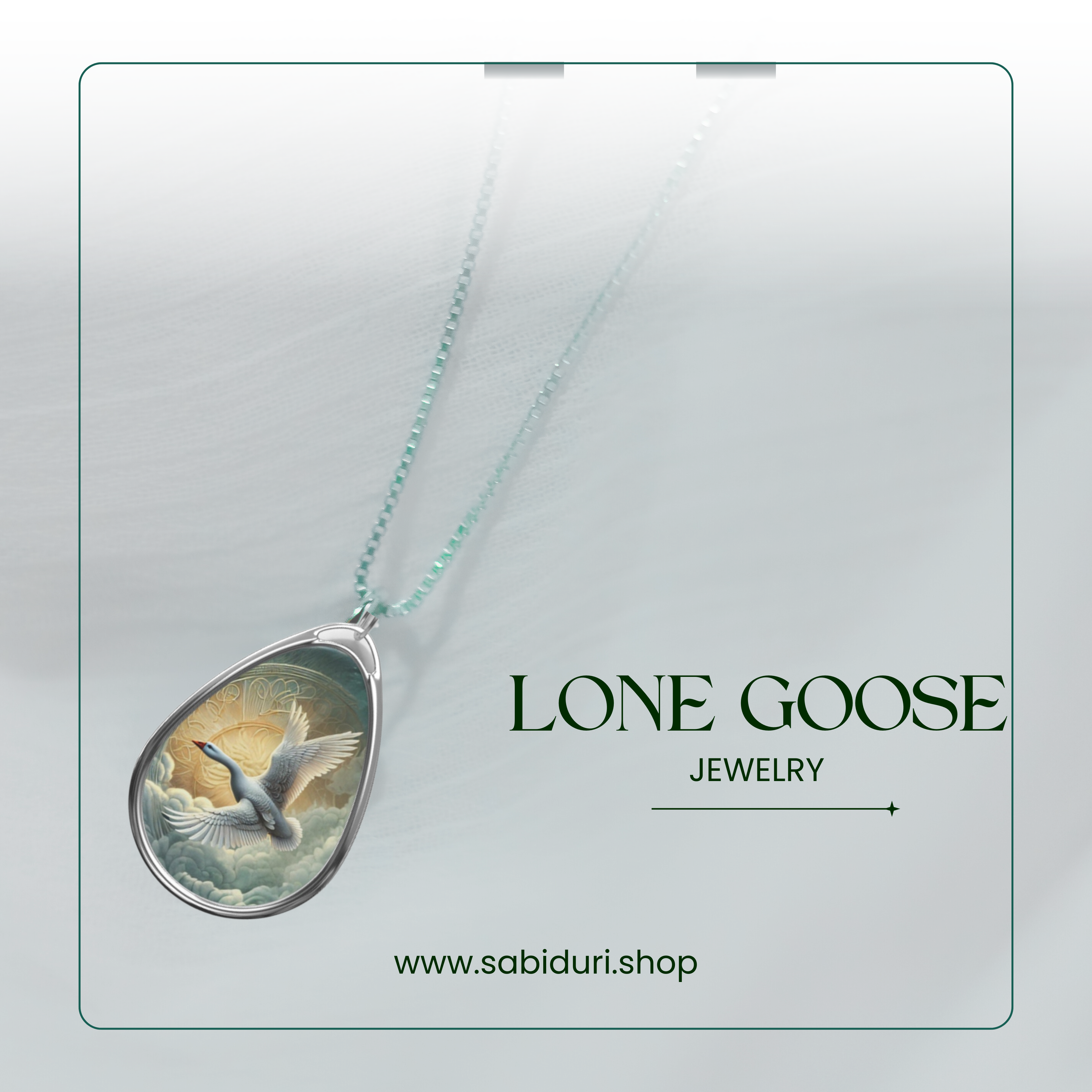 A teardrop-shaped pendant necklace with an illustration of a lone goose flying against a radiant sun, suspended by a thin chain. The text "Lone Goose Jewelry" and "www.sabiduri.shop" are displayed, promoting the jewelry brand on a soft, light-colored background.