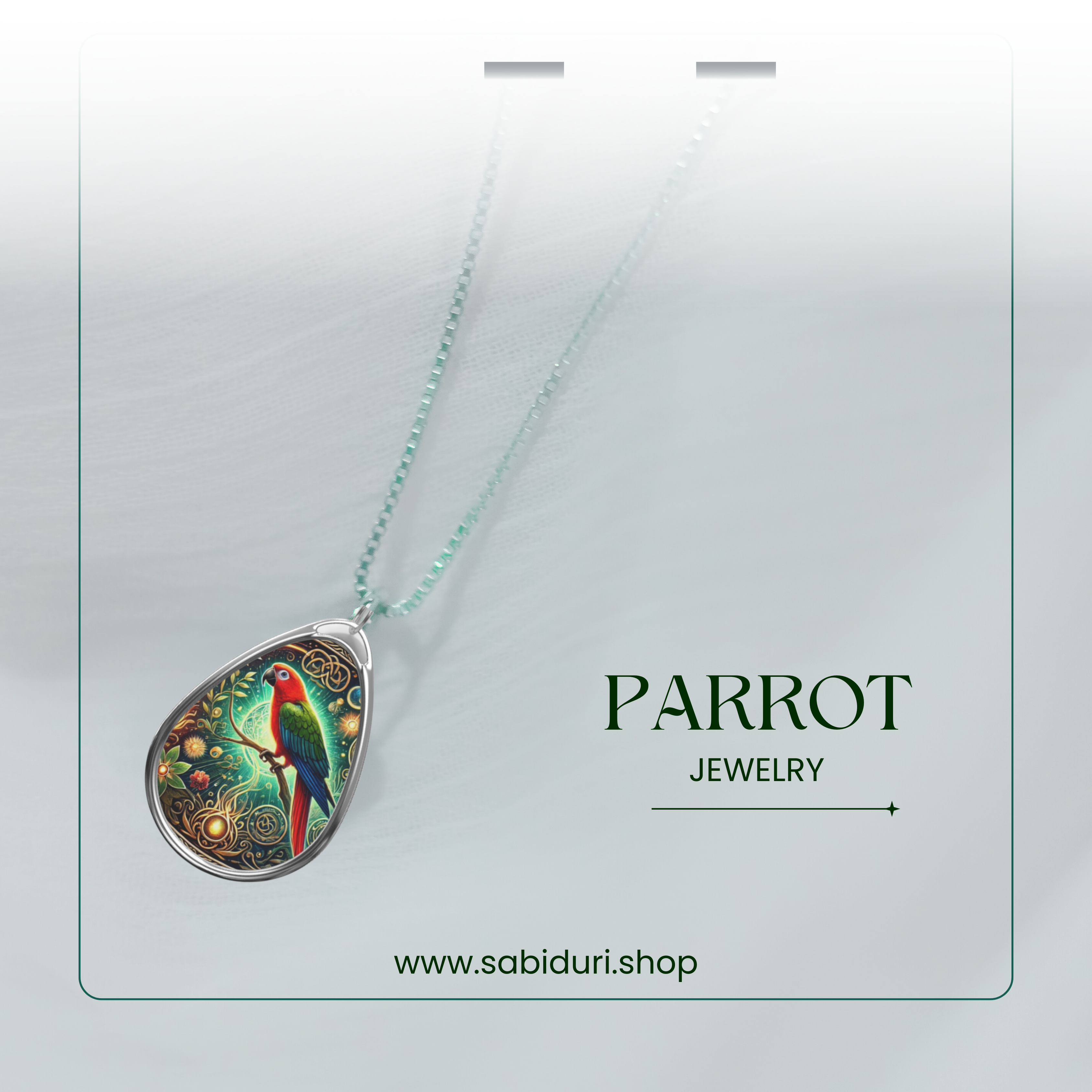 The parrot pendant hanging from a delicate silver chain, photographed against a soft, blurred background. The image emphasizes the vivid colors and intricate engravings, with the text "PARROT JEWELRY" and "www.sabiduri.shop."