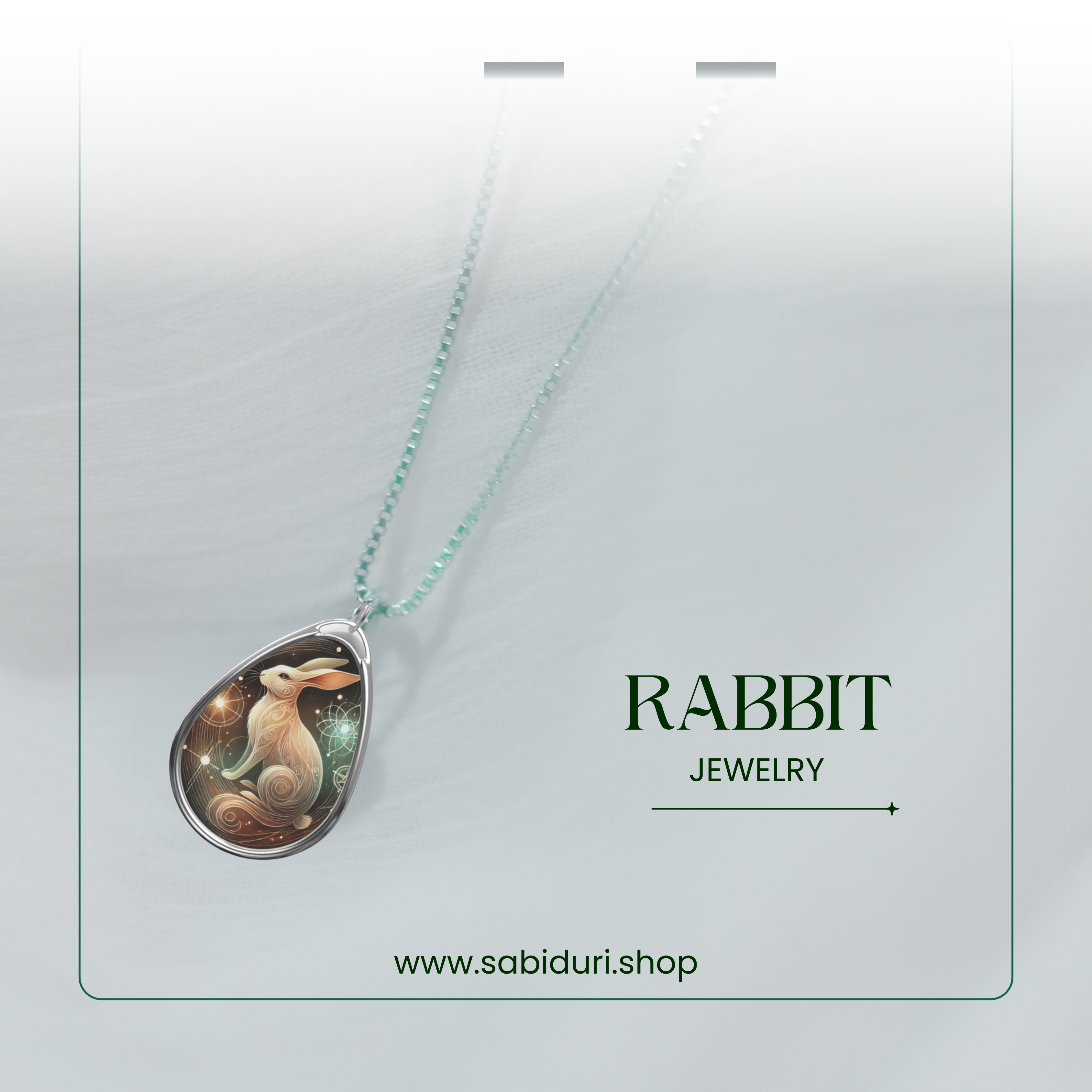 A close-up of the rabbit pendant necklace with its delicate silver chain, displayed against a soft, airy white background. The text "RABBIT JEWELRY" and "www.sabiduri.shop" is elegantly framed.