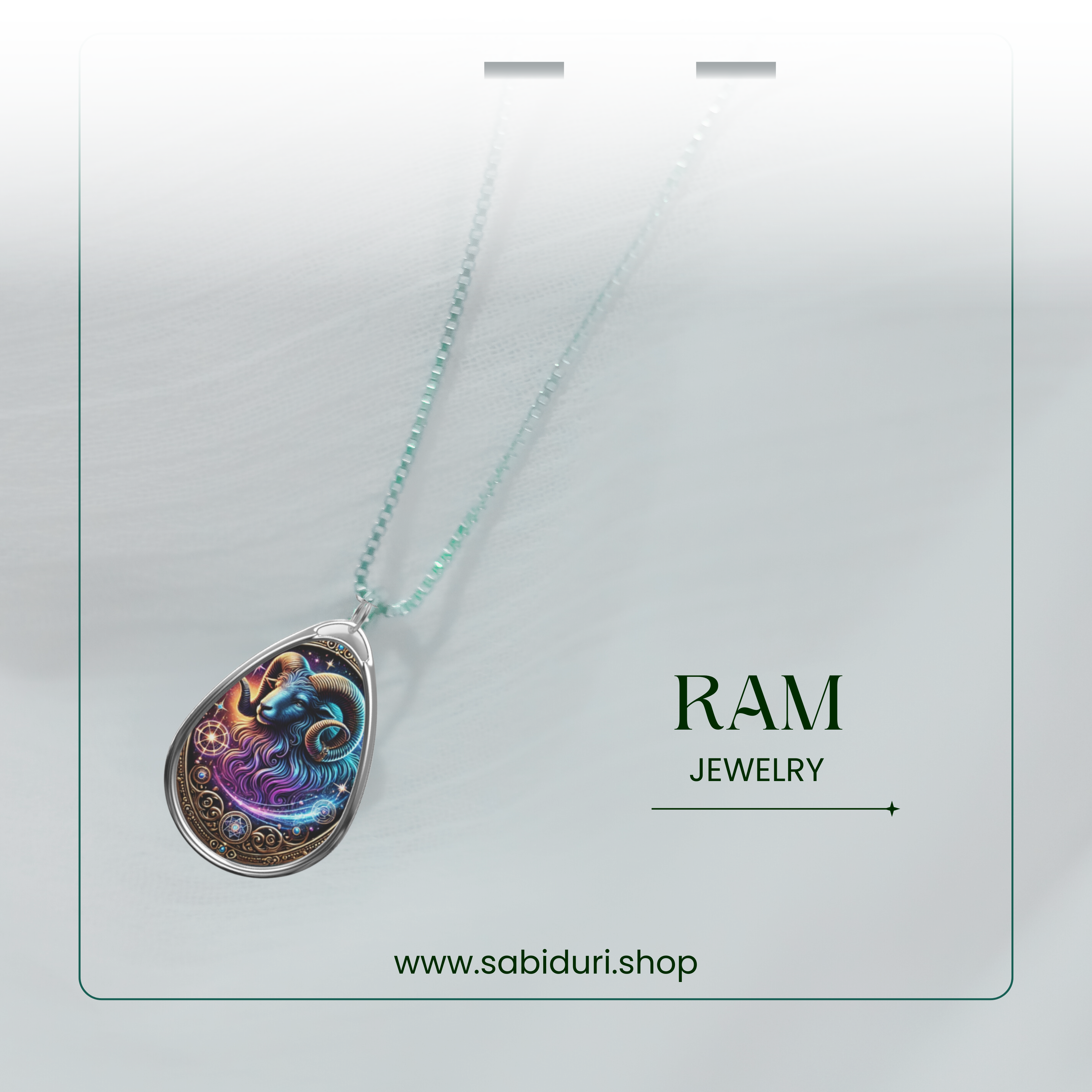 Close-up of a celestial-themed ram pendant necklace with an ethereal blue and purple ram illustration. The pendant is attached to a dainty silver chain and is displayed on a soft, white surface with the text 'RAM JEWELRY' and 'www.sabiduri.shop' written in green.