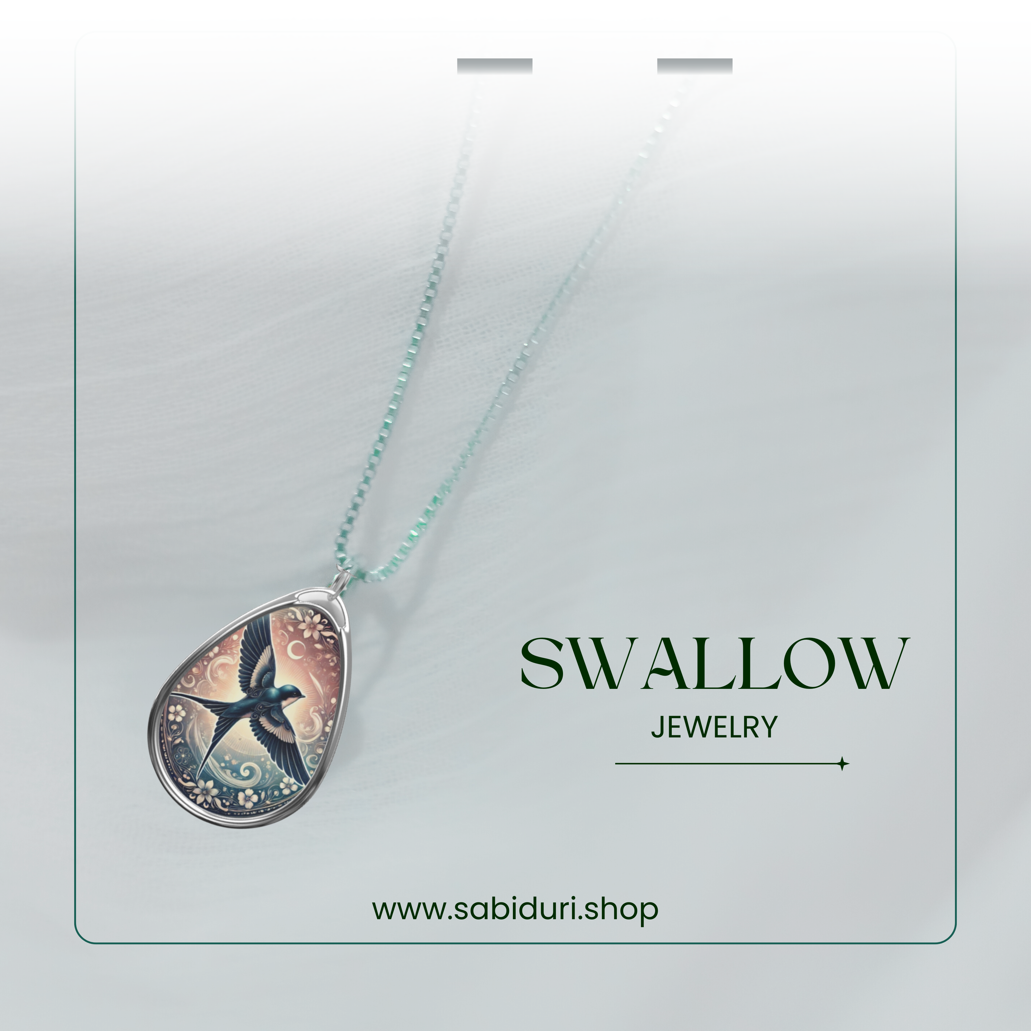 The swallow necklace is suspended on a fine silver chain, set against a soft, blurred background with a modern, minimalistic frame. The pendant features a beautifully detailed swallow flying amidst swirling wind patterns, with "SWALLOW JEWELRY" and "www.sabiduri.shop" inscribed below.