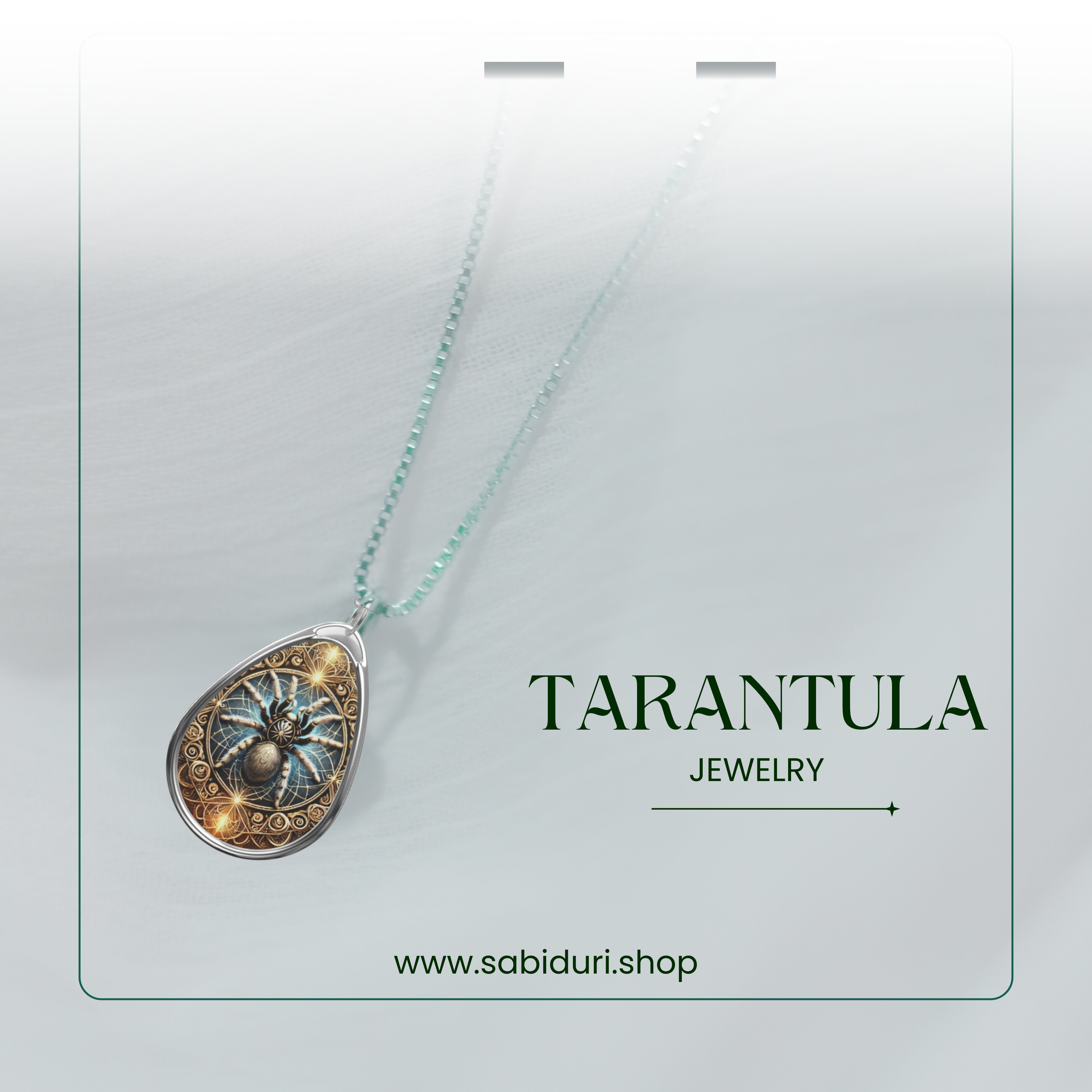 The tarantula necklace is showcased with a softly blurred white background, suspended from a delicate silver chain. The brand's website "www.sabiduri.shop" and "TARANTULA JEWELRY" text are present in a refined design.