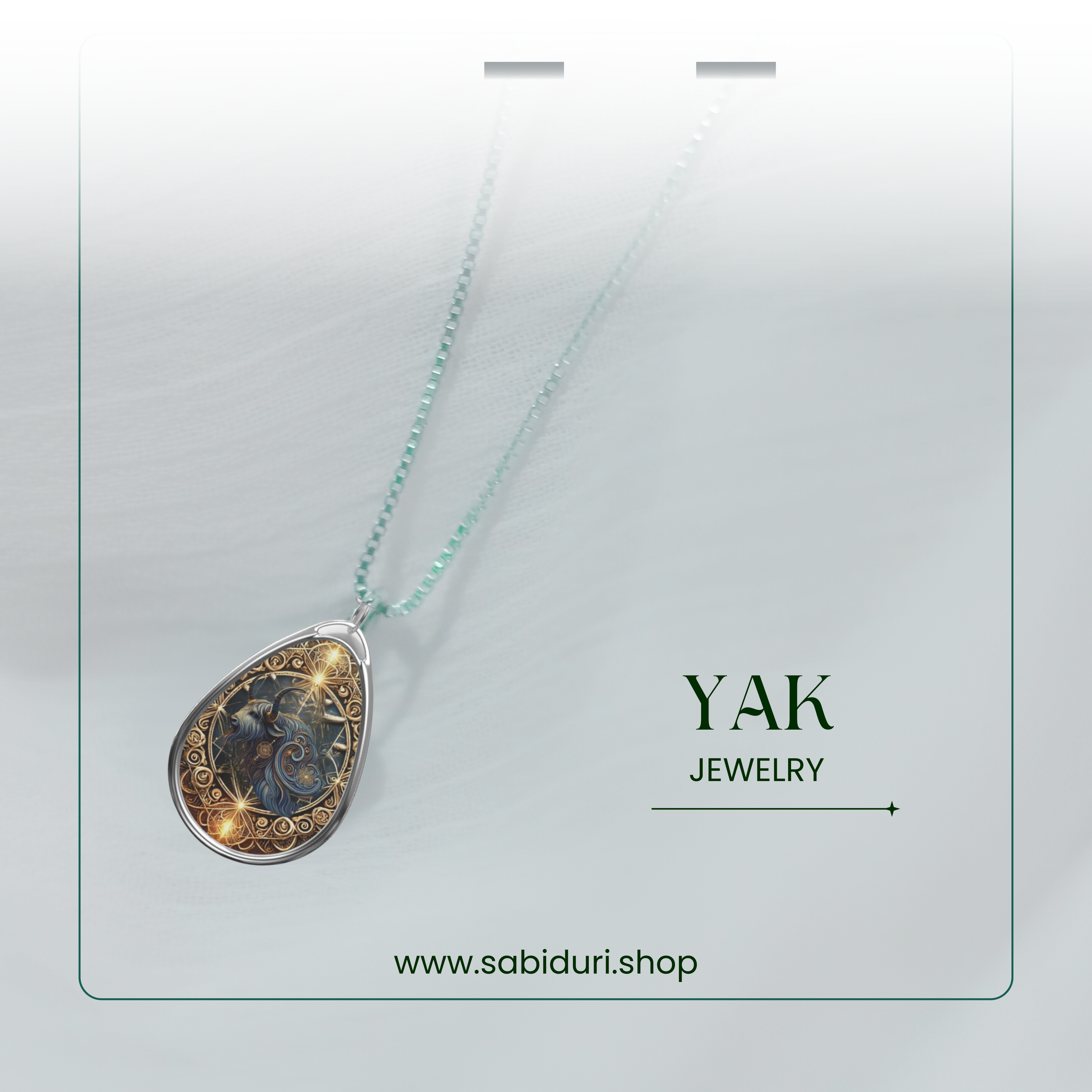 A close-up of the yak pendant hanging from a delicate chain, showcased against a soft, white background with a transparent card overlay. The words "YAK JEWELRY" and "www.sabiduri.shop" are elegantly positioned.